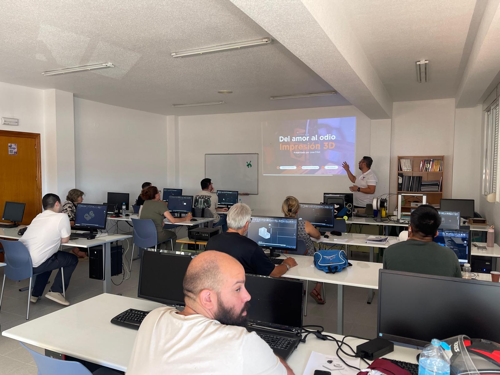 José impartiendo una clase presencial de impresión 3D, con una presentación y alumnos trabajando en sus ordenadores